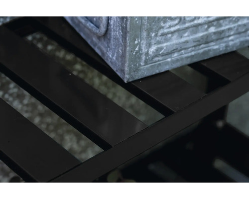 Detailaufnahme eines schwarzen Metallregals mit einer Pflanzkiste