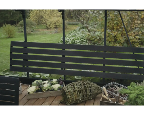 Außenaufnahme eines Gartens mit Gewächshaus und Gartenpflanzen in Behältern