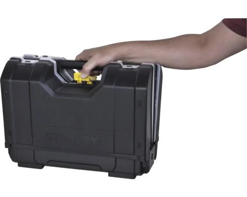 Hand trägt einen Stanley Werkzeugkoffer am Griff und betätigt den gelben Entriegelungsknopf.
