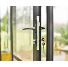 Detailansicht einer Tür mit schwarzem Rahmen und einem Schloss mit Schlüssel