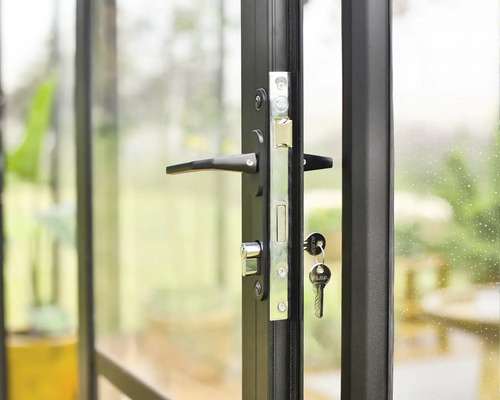 Detailansicht einer Tür mit schwarzem Rahmen und einem Schloss mit Schlüssel