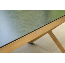 Nahaufnahme eines Siena Garden Tischs mit dunkler, strukturierter Tischplatte und Holzgestell mit Siena Garden Logo.