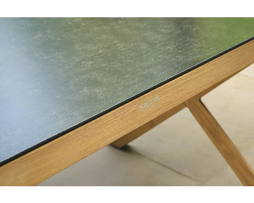 Nahaufnahme eines Siena Garden Tischs mit dunkler, strukturierter Tischplatte und Holzgestell mit Siena Garden Logo.