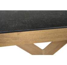 Nahaufnahme eines Tisches mit einer dunklen strukturierten Platte und einem Holzrahmen.