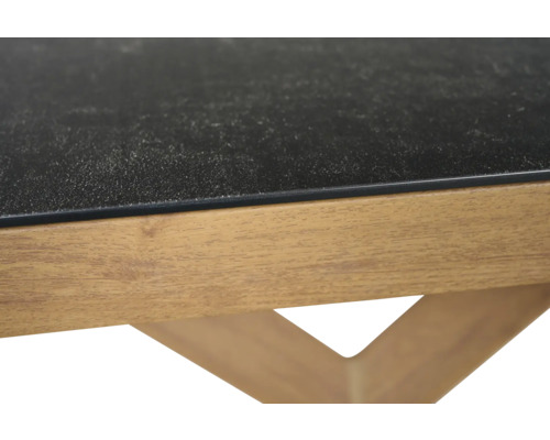 Nahaufnahme eines Tisches mit einer dunklen strukturierten Platte und einem Holzrahmen.