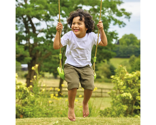 Lachender Junge auf Gartenschaukel