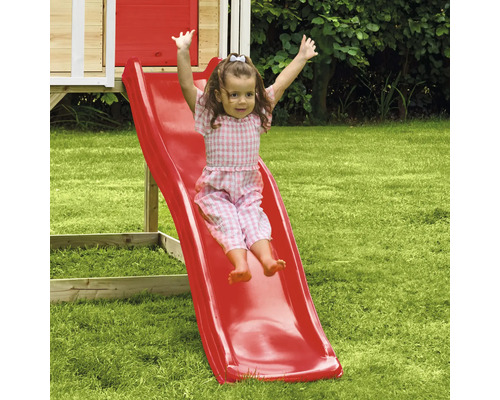 Mädchen rutscht auf einer roten Kinderrutsche im Garten