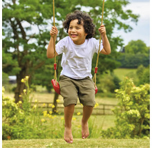 Junge schwingt auf einer Gartenschaukel mit Seilen und Sitz