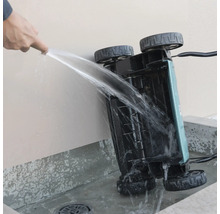 Reinigung der Unterseite eines Vertikutierers mit einem Wasserstrahl.