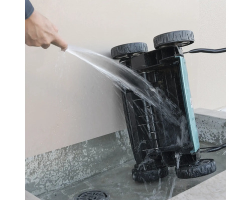 Reinigung der Unterseite eines Vertikutierers mit einem Wasserstrahl.