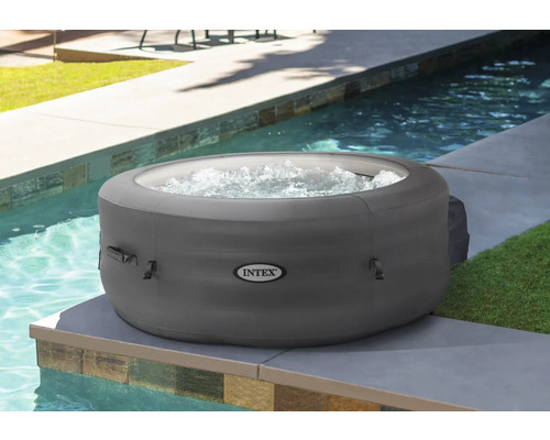Aufblasbarer grauer Whirlpool der Marke Intex neben einem Pool.