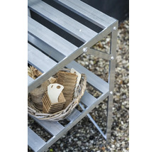 Aluminium-Pflanzregal mit einem Weidenkorb, der Anzuchttöpfe aus Fasern und Bindfaden auf einer Ablage enthält.