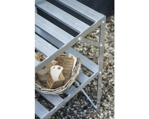 Aluminium-Pflanzregal mit einem Weidenkorb, der Anzuchttöpfe aus Fasern und Bindfaden auf einer Ablage enthält.