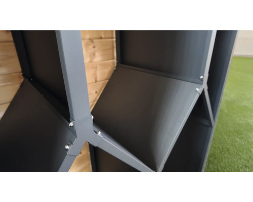 Detailansicht einer Eckverbindung aus grauem Metall an einem Gartenhaus mit sichtbaren Schrauben vor einer Holzwand.