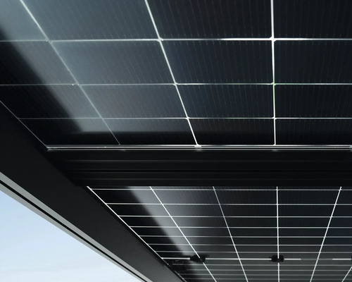 Nahaufnahme von Photovoltaik Modulen in einem Terrassendach mit dunkler Rahmenkonstruktion.