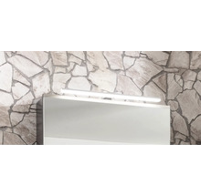 LED-Badleuchte über einem Spiegelschrank an einer Wand aus Naturstein.