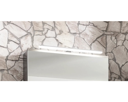 LED-Badleuchte über einem Spiegelschrank an einer Wand aus Naturstein.