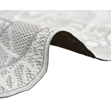 Nahaufnahme eines flachgewebten Teppichs mit Fokus auf die Textur und die eingefasste Kante.