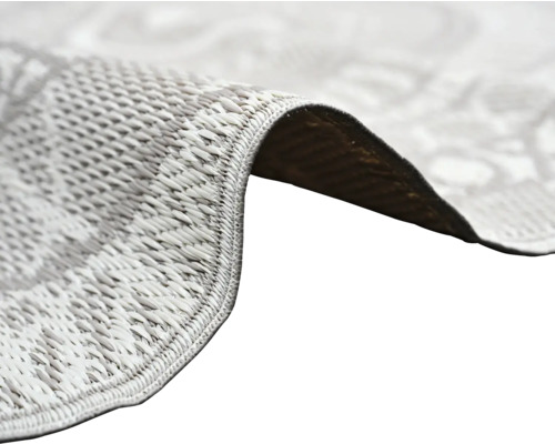 Nahaufnahme eines flachgewebten Teppichs mit Fokus auf die Textur und die eingefasste Kante.