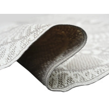 Nahaufnahme eines gewebten Teppichs mit detaillierter Oberflächenstruktur und geketteltem Rand.