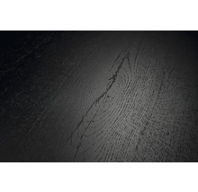 Detailansicht einer dunklen Bodenbelagsoberfläche mit Holzmaserung und sichtbarem Astloch.