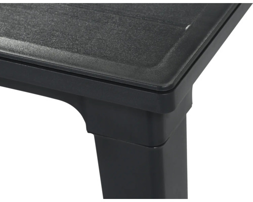 Detailansicht der Ecke eines schwarzen Kunststofftisches mit strukturierter Oberfläche.