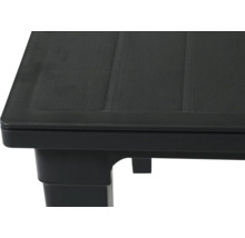 Detailaufnahme einer schwarzen Gartentisch-Ecke aus Kunststoff mit Holzoptik-Struktur.