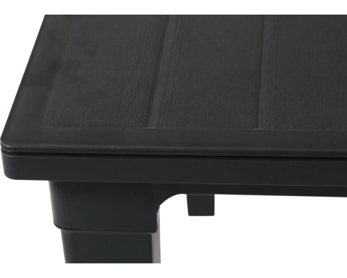 Detailaufnahme einer schwarzen Gartentisch-Ecke aus Kunststoff mit Holzoptik-Struktur.