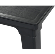 Ecke eines schwarzen Kunststoff-Gartentisches mit strukturierter Tischplatte.