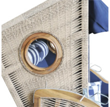 Detailansicht eines Strandkorbs mit Geflecht und einem runden Bullaugenfenster mit Holzrahmen.