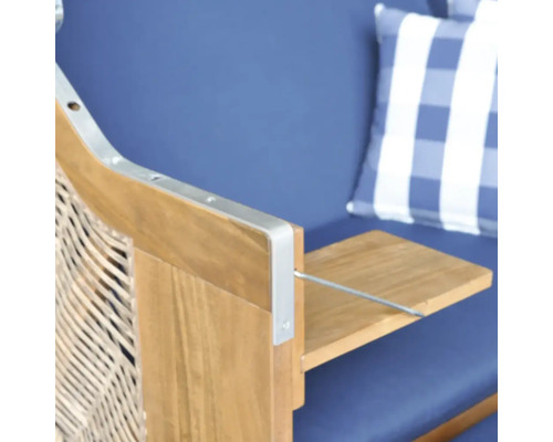 Detail eines Strandkorbs mit ausklappbarem Seitentisch aus Holz und blauem Polster.