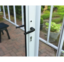 Nahaufnahme eines schwarzen Türgriffs mit Schloss an einem weißen Rahmen eines Gewächshauses oder einer Terrassentür.