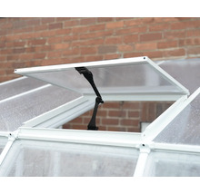 Geöffnetes Gewächshausdachfenster mit weißem Rahmen und schwarzem manuellem Fensteraufsteller.