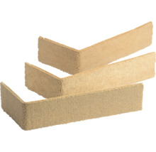 Drei beige L-förmige Eckriemchen Verblendsteine mit sandiger Oberfläche für die Wandverkleidung.