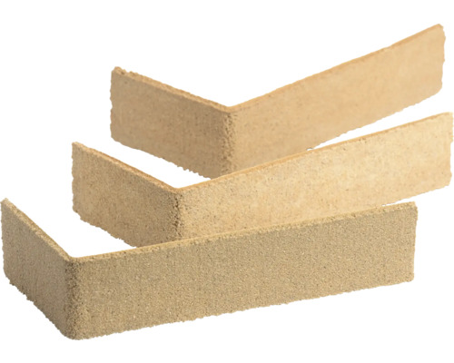 Drei beige L-förmige Eckriemchen Verblendsteine mit sandiger Oberfläche für die Wandverkleidung.