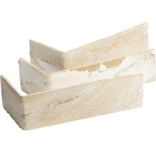 L-förmige beige Eckriemchen für Wandverkleidungen mit grober Steinoptik.