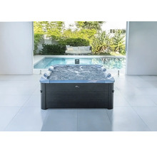 Moderner rechteckiger MSpa Whirlpool mit Sprudelfunktion und Nackenstützen in hellem Raum mit Pool- und Gartenblick.