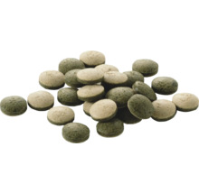 Grüne und beige Futtertabletten für Fische in runder Form.