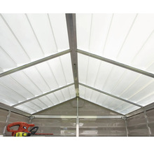 Innenansicht eines Gerätehauses mit lichtdurchlässigem Satteldach und Metallrahmen. Eine Heckenschere liegt auf einem Regal.