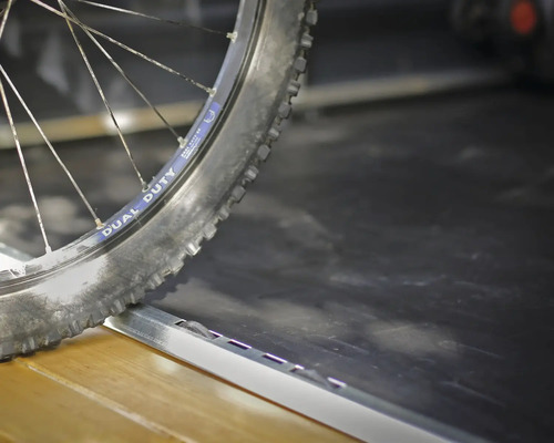 Fahrradreifen auf einer Laderampe oder einem Übergangsprofil aus Metall.
