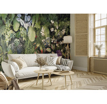 Wohnzimmer mit Fototapete mit tropischen Pflanzen, weißem Sofa und Holzmöbeln. Heller, organisierter Raum mit Parkettboden.