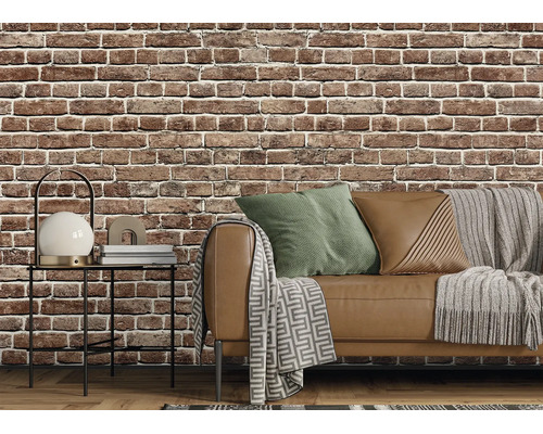 Vlies-Tapete in Backstein-Optik in einem Wohnzimmer im Industrial-Style mit Sofa, Beistelltisch und Textilien.