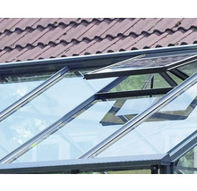 Gewächshausdach mit einem geöffneten Dachfenster aus Glas und dunklem Metallrahmen.