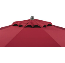 Nahaufnahme eines roten Sonnenschirms mit Windöffnung und einer dunklen Abdeckkappe an der Spitze.