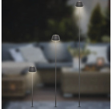Drei verschieden hohe LED-Erdspießleuchten für den Garten mit plissierten Lampenschirmen in einem stimmungsvollen Außenbereich.