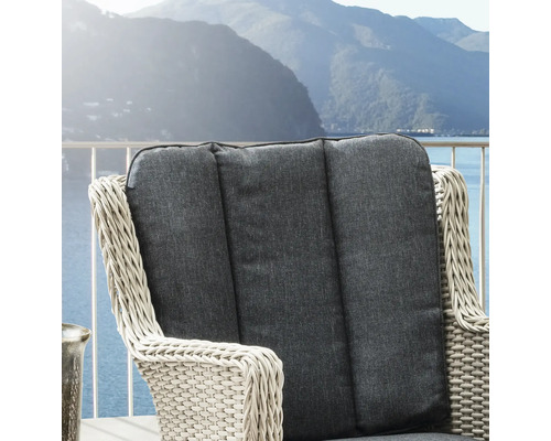 Gartenstuhl aus Polyrattan mit grauem Rückenkissen auf einem Balkon mit Blick auf See und Berge.
