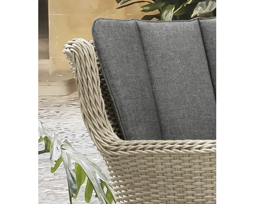 Detail eines Gartenstuhls aus beigem Polyrattan-Geflecht mit grauem Sitzkissen.