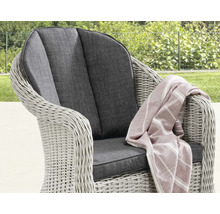 Gartensessel aus Polyrattan mit dunklen Sitz- und Rückenkissen sowie einer gestreiften Decke im Garten.