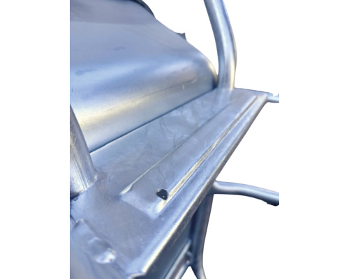 Detailaufnahme eines verzinkten Metallrahmens einer Schubkarre mit Bohrung für die Befestigung.