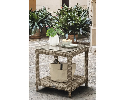 Quadratischer Gartenbeistelltisch aus grauem Polyrattan mit Glasplatte und Ablagefläche, dekoriert mit Vase und Schale auf einer Terrasse.